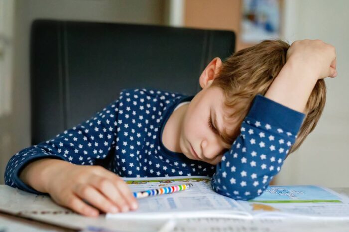 Müdes Kind macht Hausaufgaben