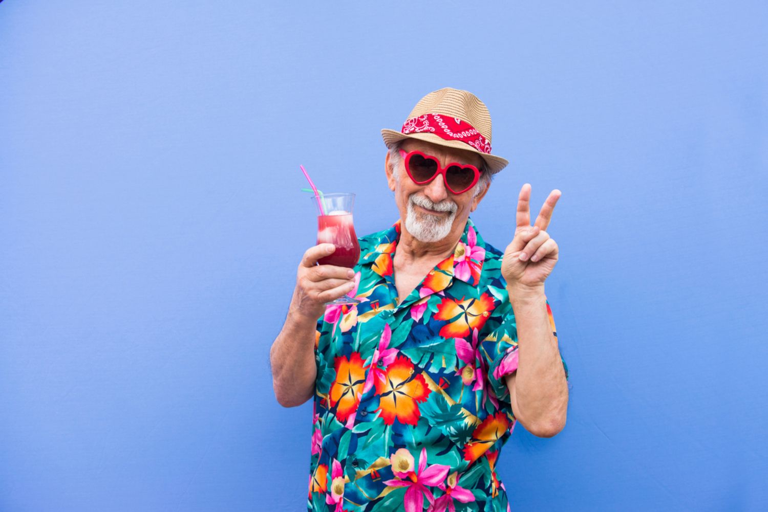 Alter Mann mit Sonnenbrille und Cocktail