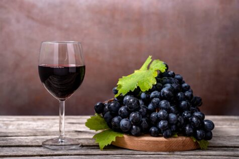 Glas mit rotem Wein und rote Trauben